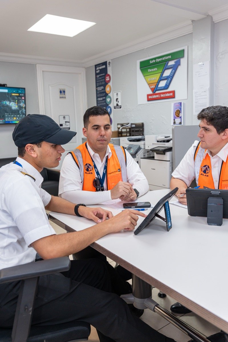 Instructores y estudiantes de ALAS Flight Academy revisando un briefing de seguridad